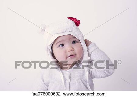Stock Image - Baby girl wearing bear hat, portrait. Fotosearch