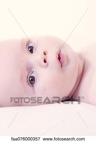 Stock Photo - Baby looking at camera, portrait. Fotosearch