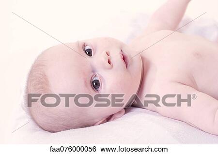 Baby lying on back, looking at camera View Large Photo Image Stock Photograph - Baby lying on back, looking at camera. Fotosearch