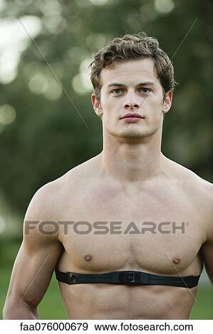 Stock Photo - Barechested young man wearing heart rate monitor. Fotosearch