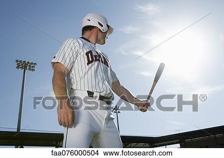 Picture - Baseball player holding bat, looking over shoulder. Fotosearch