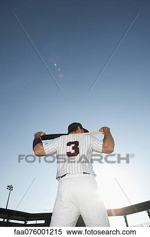 Stock Photography - Baseball player holding bat, rear view. Fotosearch
