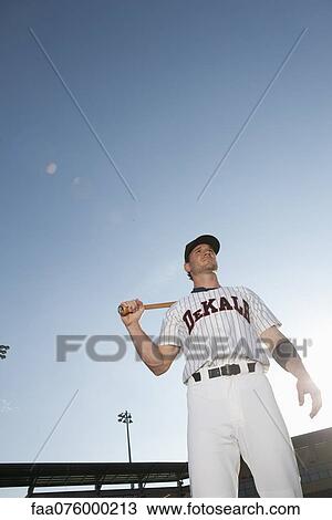 Stock Image - Baseball player holding bat. Fotosearch
