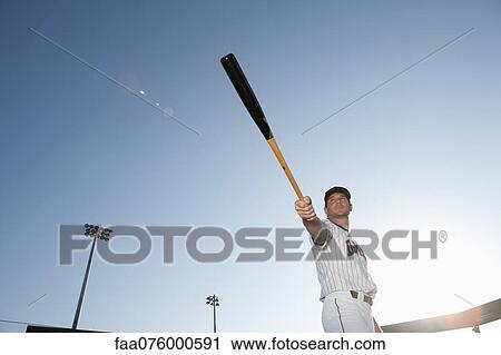 Stock Image - Baseball player holding out baseball bat. Fotosearch