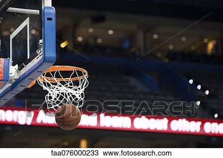 Stock Image - Basketball in hoop, blurred motion. Fotosearch