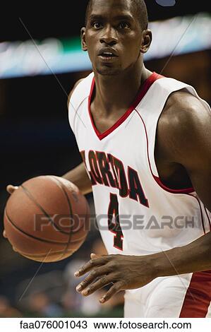 Stock Image - Basketball player dribbling ball. Fotosearch