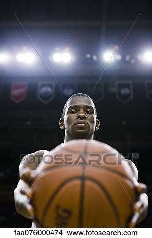 Picture - Basketball player holding basketball. Fotosearch