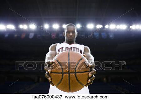 Basketball player holding basketball, focus on foreground View Large Photo Image Stock Photo - Basketball player holding basketball, focus on foreground. Fotosearch