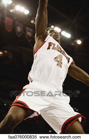 Stock Photography - Basketball player jumping in air, low angle view. Fotosearch