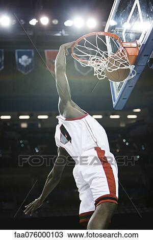 Basketball player slam dunking basketball View Large Photo Image Stock Image - Basketball player slam dunking basketball. Fotosearch