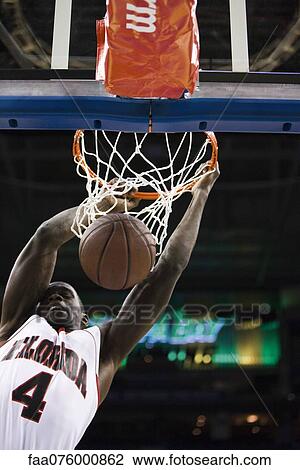 Basketball player slam dunking basketball View Large Photo Image Stock Image - Basketball player slam dunking basketball. Fotosearch