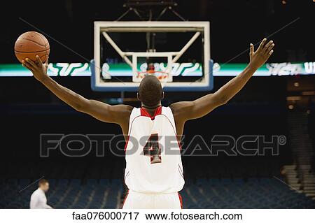 Basketball player standing in basketball court with arms outstretched, rear view View Large Photo Image Stock Photo - Basketball player standing in basketball court with arms outstretched, rear view. Fotosearch