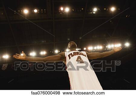 Basketball player standing with arms out, low angle view View Large Photo Image Stock Photo - Basketball player standing with arms out, low angle view. Fotosearch