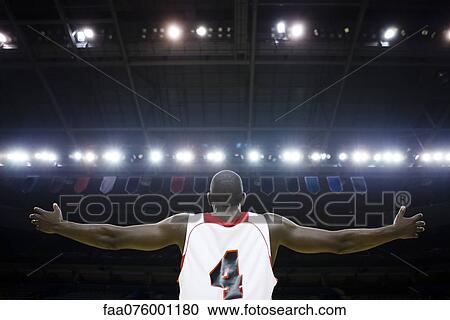 Stock Image - Basketball player with arms outstretched, rear view. Fotosearch