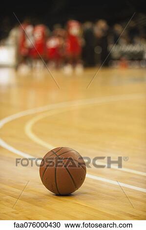 Stock Image - Basketball resting on court. Fotosearch
