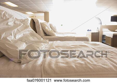 Stock Image - Beds in empty room. Fotosearch
