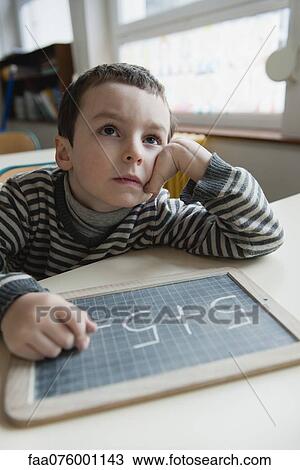Stock Image - Boy solving math problem. Fotosearch