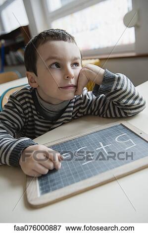 Stock Photo - Boy solving math problem. Fotosearch