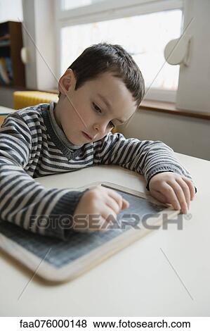 Boy writing on chalkboard View Large Photo Image Stock Photo - Boy writing on chalkboard. Fotosearch