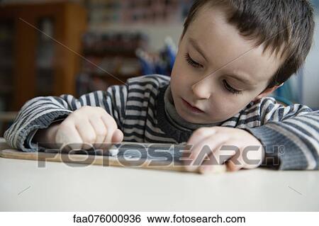 Stock Photograph - Boy writing on chalkboard. Fotosearch