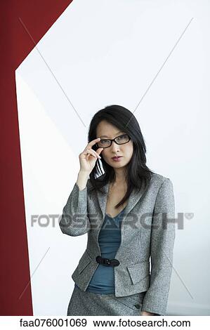 Stock Photo - Businesswoman adjusting glasses, portrait. Fotosearch