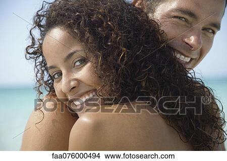 Couple embracing at the beach, portrait View Large Photo Image Picture - Couple embracing at the beach, portrait. Fotosearch