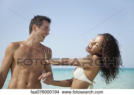 Picture - Couple having fun together at the beach. Fotosearch