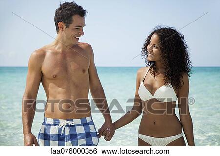 Stock Photograph - Couple holding hands at the beach. Fotosearch