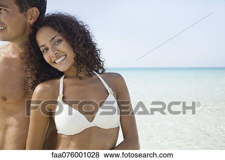 Stock Photo - Couple relaxing together at the beach, portrait. Fotosearch
