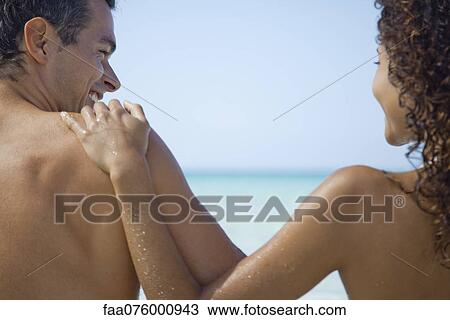 Stock Image - Couple together at the beach, rear view. Fotosearch