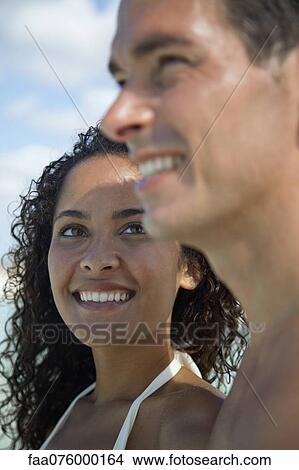 Picture - Couple together outdoors, woman smiling at man. Fotosearch