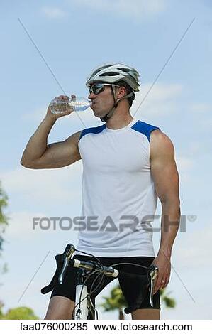 Stock Photography - Cyclist drink bottle water, portrait. Fotosearch
