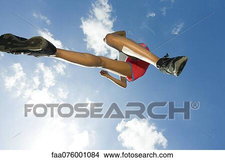 Female athlete jumping in air, directly below View Large Photo Image Picture - Female athlete jumping in air, directly below. Fotosearch