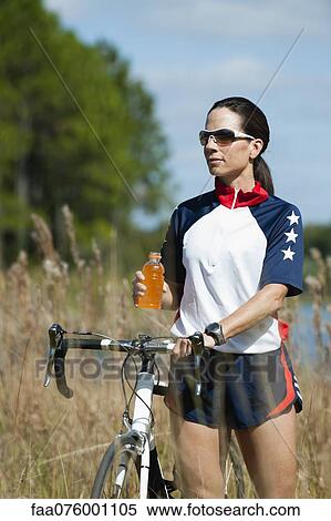 Stock Photography - Female cyclist taking break. Fotosearch