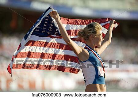 Female medalist holding up American flag View Large Photo Image Stock Photo - Female medalist holding up American flag. Fotosearch