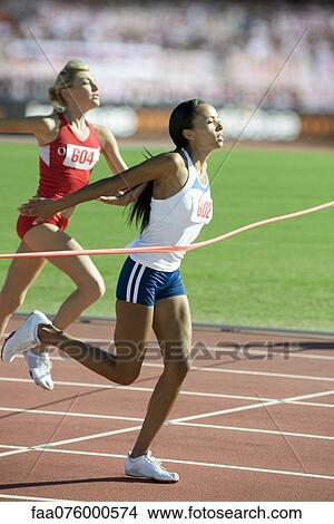 Picture - Female runner crossing finish line. Fotosearch