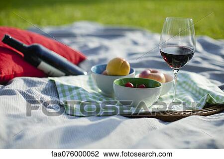 Stock Image - Food and wine on picnic blanket. Fotosearch