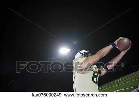 Football player catching football View Large Photo Image Stock Photo - Football player catching football. Fotosearch