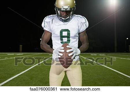 Football player holding football View Large Photo Image Stock Image - Football player holding football. Fotosearch
