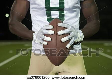 Football player holding football, cropped View Large Photo Image Stock Image - Football player holding football, cropped. Fotosearch