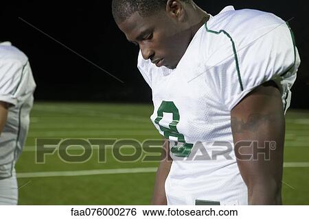 Football player looking down in disappointment View Large Photo Image Stock Photograph - Football player looking down in disappointment. Fotosearch