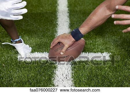 Stock Photo - Football players at line of scrimmage, cropped. Fotosearch