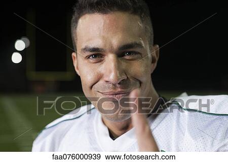 Stock Photo - Football smiling confidently at camera, portrait. Fotosearch