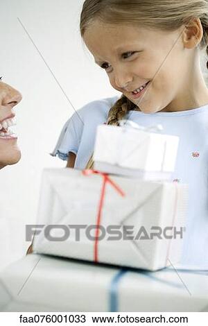 Stock Image - Girl giving her mother gifts. Fotosearch
