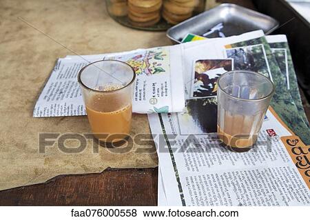 Stock Photo - Glasses of chai tea and newspaper on table. Fotosearch