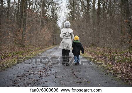 Grandmother and grandson walking in woods, holding hands, rear view View Large Photo Image Stock Photograph - Grandmother and grandson walking in woods, holding hands, rear view. Fotosearch