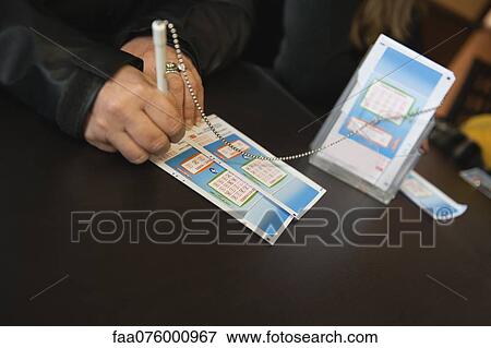 Stock Photo - Hands of woman filling out lottery tockets. Fotosearch