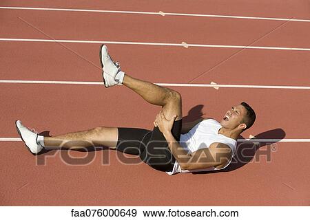 Stock Photo - Injured runner lying on running track. Fotosearch