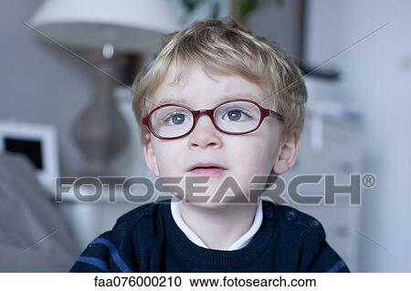 Stock Image - Little boy looking away in thought, portrait. Fotosearch