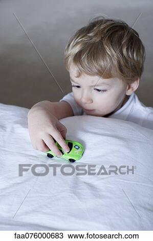 Stock Image - Little boy playing with toy car. Fotosearch